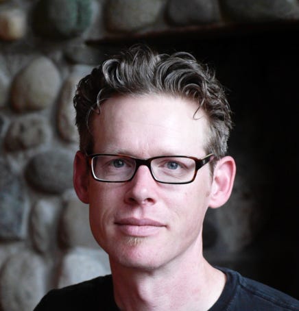 A skilled luthier works on an acoustic guitar in a well-organized workshop.